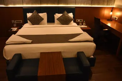 a bedroom with a large bed in a room at Poppys Vista Hotel in Thirumurugan Poondi