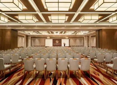 a conference room with rows of chairs and a podium at The Residency Towers Coimbatore in Coimbatore