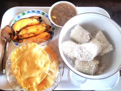 a tray with a plate of food and a bowl of bread at Landy Queen in Munnar
