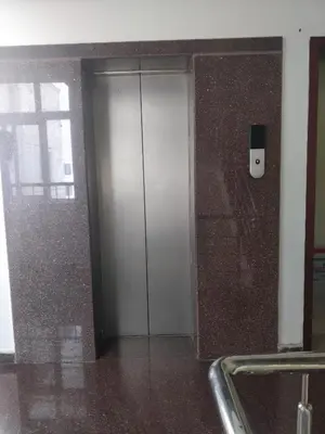a silver elevator with a cell phone on a wall at Tulip Suites in Coimbatore