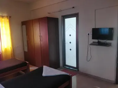a small room with a window and a television at Tulip Suites in Coimbatore