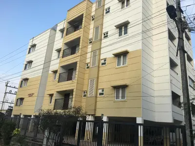 a tall building with a fence in front of it at Tulip Suites in Coimbatore