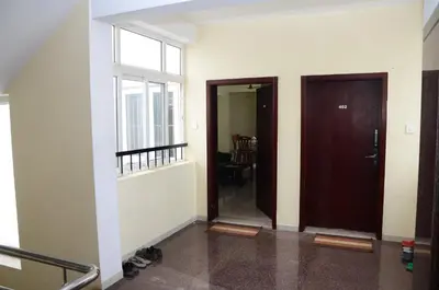 an empty hallway with two doors and a window at Tulip Suites in Coimbatore