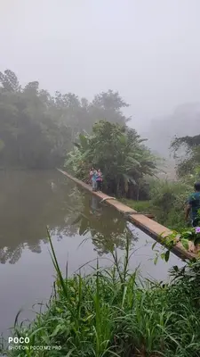 a group of people standing on a bridge over a body of water at Dreams Home Estate Stay in Suntikoppa