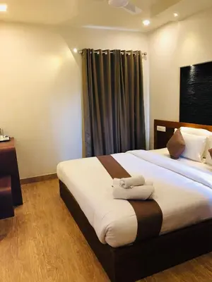 a bedroom with two beds with towels on them at Sandalo Castle Resorts in Gūdalūr
