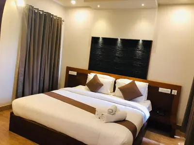 a bedroom with a bed with two towels on it at Sandalo Castle Resorts in Gūdalūr