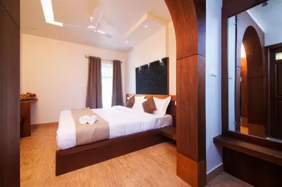 a bedroom with a bed and a window at Sandalo Castle Resorts in Gūdalūr