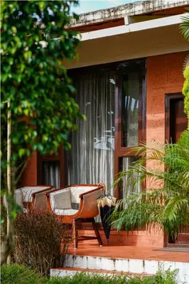 a pair of chairs sitting on the porch of a house at Sixth Element in Kushālnagar