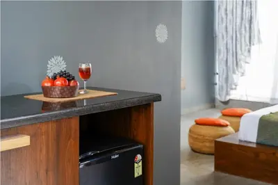 a table with a glass of wine and a bowl of fruit at Sixth Element in Kushālnagar