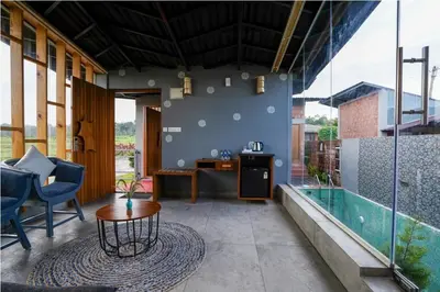 a patio with a table and a swimming pool at Sixth Element in Kushālnagar