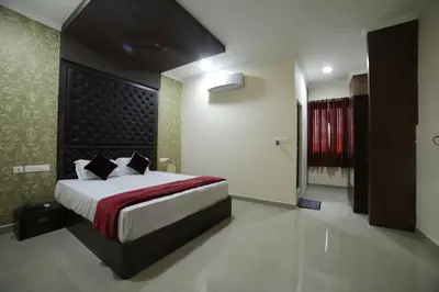 a bedroom with a large bed with a red curtain at Shivalaya Residency in Trichūr
