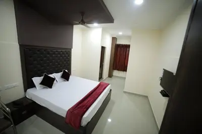 a bedroom with a bed with white sheets and pillows at Shivalaya Residency in Trichūr