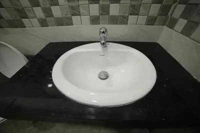 a white sink in a bathroom with a tap at Shivalaya Residency in Trichūr