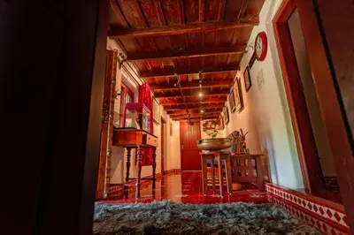 a hallway with a table and a clock on the wall at Anamala Serenity Homestay Kerala in Lakkidi