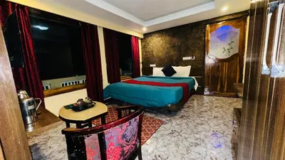 a hotel room with a bed and a table at Mountain View cottage in Ooty