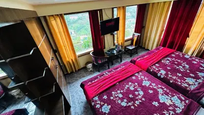 a living room with a red bed and a television at Mountain View cottage in Ooty