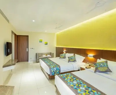 a hotel room with two beds and a yellow wall at Hotel Divine Fort in Palani
