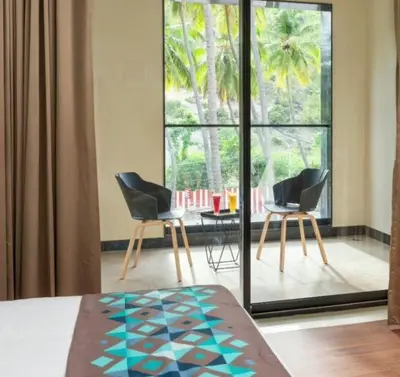 two chairs and a table in a room with a window at Hotel Divine Fort in Palani