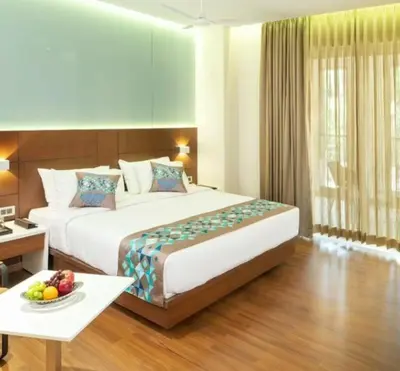 a hotel room with a large bed and a table at Hotel Divine Fort in Palani