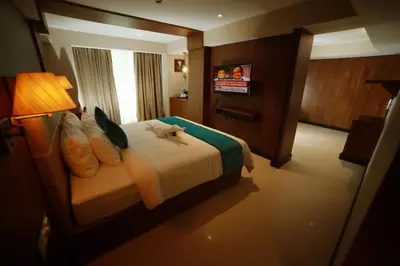 a hotel room with a bed with a stuffed animal on it at YASH INTERNATIONAL in Kozhikode