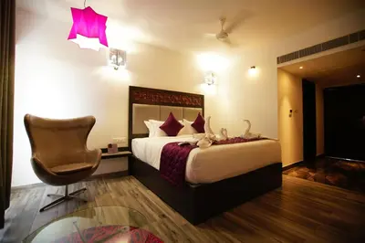 a hotel room with a bed and a chair at Regency Palani by GRT Hotels in Palani