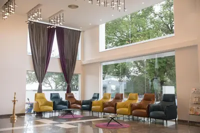 a waiting room with chairs and windows at Regency Palani by GRT Hotels in Palani
