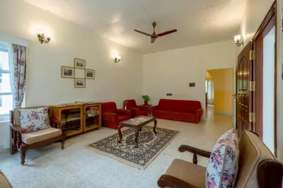 a living room with red furniture and a red couch at Ama Plantation Trails Coorg in Gonikoppal