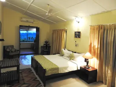 a bedroom with a bed and a television in it at Ama Plantation Trails Coorg in Gonikoppal
