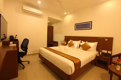 a hotel room with a bed and a desk at Victory Inn Park Residency in Kunnamkulam