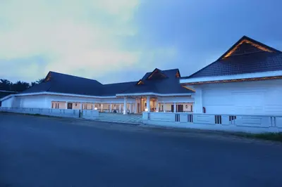 a row of white buildings with black roofs at Victory Inn Park Residency in Kunnamkulam