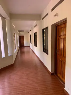 an empty hallway with a wooden door in a building at Airavatham Apartments in Guruvāyūr