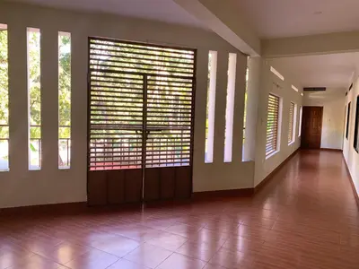 a large room with wooden doors and windows at Airavatham Apartments in Guruvāyūr