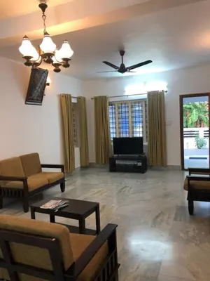 a living room with a couch and a flat screen tv at Sannidhi Home stay in Guruvāyūr