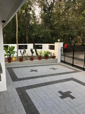 a patio with potted plants and a black fence at Sannidhi Home stay in Guruvāyūr