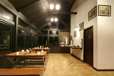 a restaurant with wooden tables and chairs in a room at Logan Camp Ooty in Coonoor