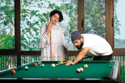 a man and a woman standing next to a pool table at Morickap Resort in Vythiri