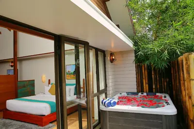 a guest room with a bed and a room with a window at Morickap Resort in Vythiri