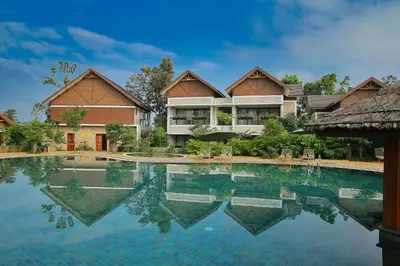 a swimming pool in front of a house at Morickap Resort in Vythiri