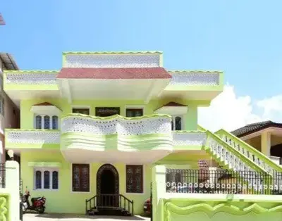 a large yellow building with a balcony on it at Long Wood Hills Cottage in Ooty