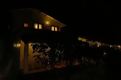 a building at night with a tree in front of it at The Tamarillo in Ooty