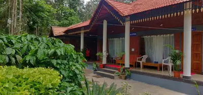a red house with a red roof and some plants at RAI COTTAGE @ Coorg ,Suntikoppa in Suntikoppa
