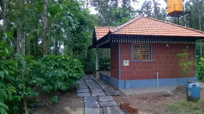 a small red house with a red roof at RAI COTTAGE @ Coorg ,Suntikoppa in Suntikoppa