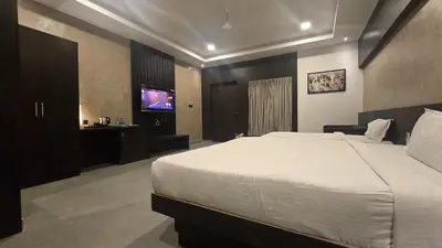 a bedroom with a large bed and a tv at D Wayfarer Inn Resort in Erode