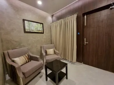 a living room with two chairs and a table at D Wayfarer Inn Resort in Erode