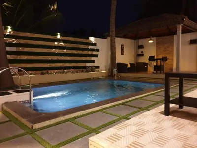 a swimming pool in the middle of a patio at night at D Wayfarer Inn Resort in Erode