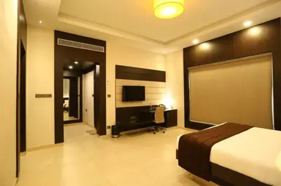 a bedroom with a bed and a flat screen tv at D Wayfarer Inn Resort in Erode