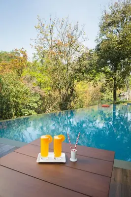 a table with two yellow glasses on top of it at Abad Brookside Wayanad in Vythiri