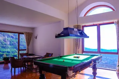 a room with a pool table and a large window at La Montana by TGI in Ooty