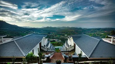 a view of roofs of buildings with mountains in the background at La Montana by TGI in Ooty