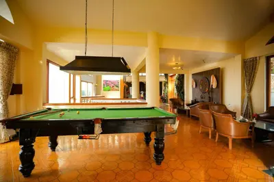a living room with a pool table in a room at La Montana by TGI in Ooty